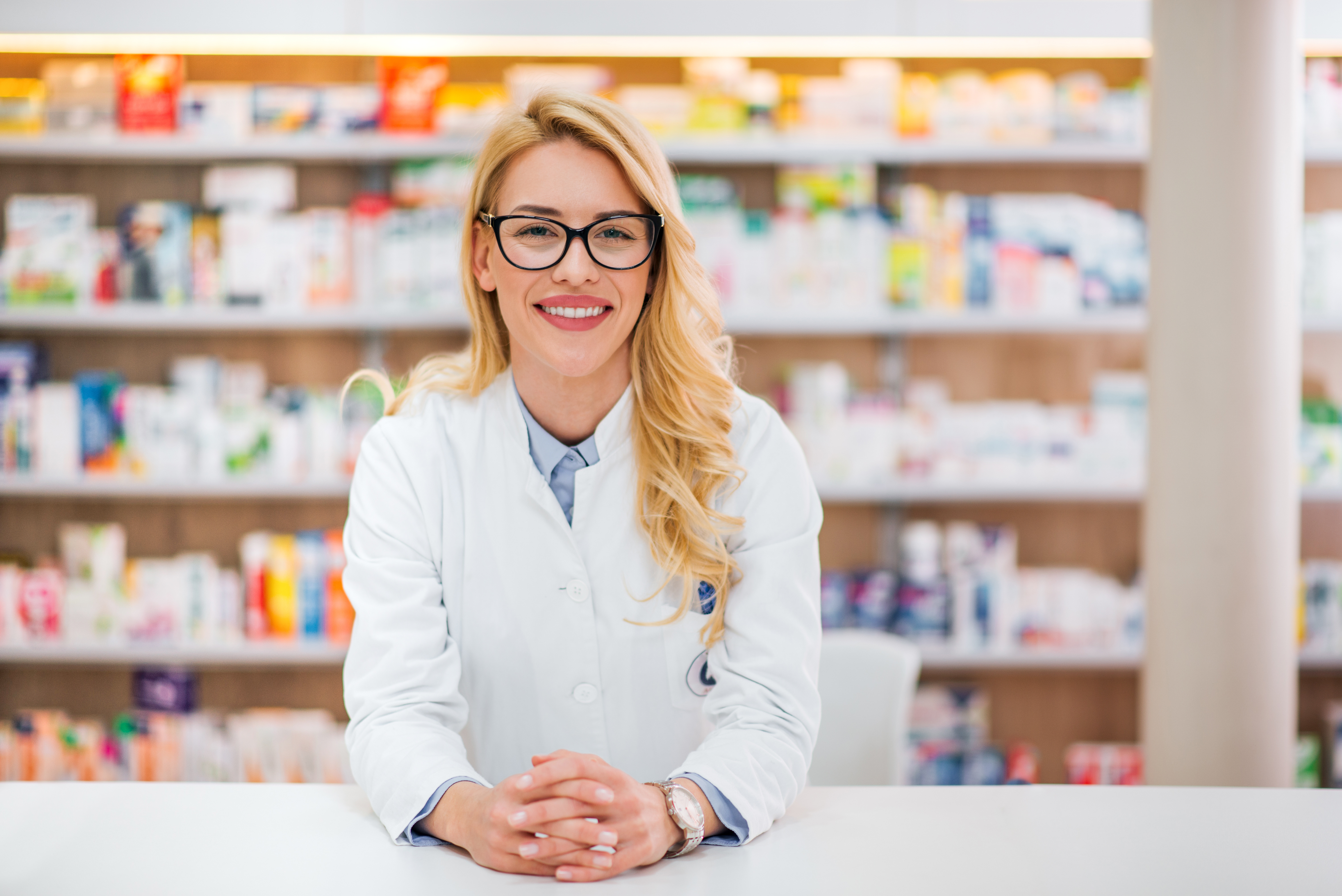 Female pharmacist at counter smiling