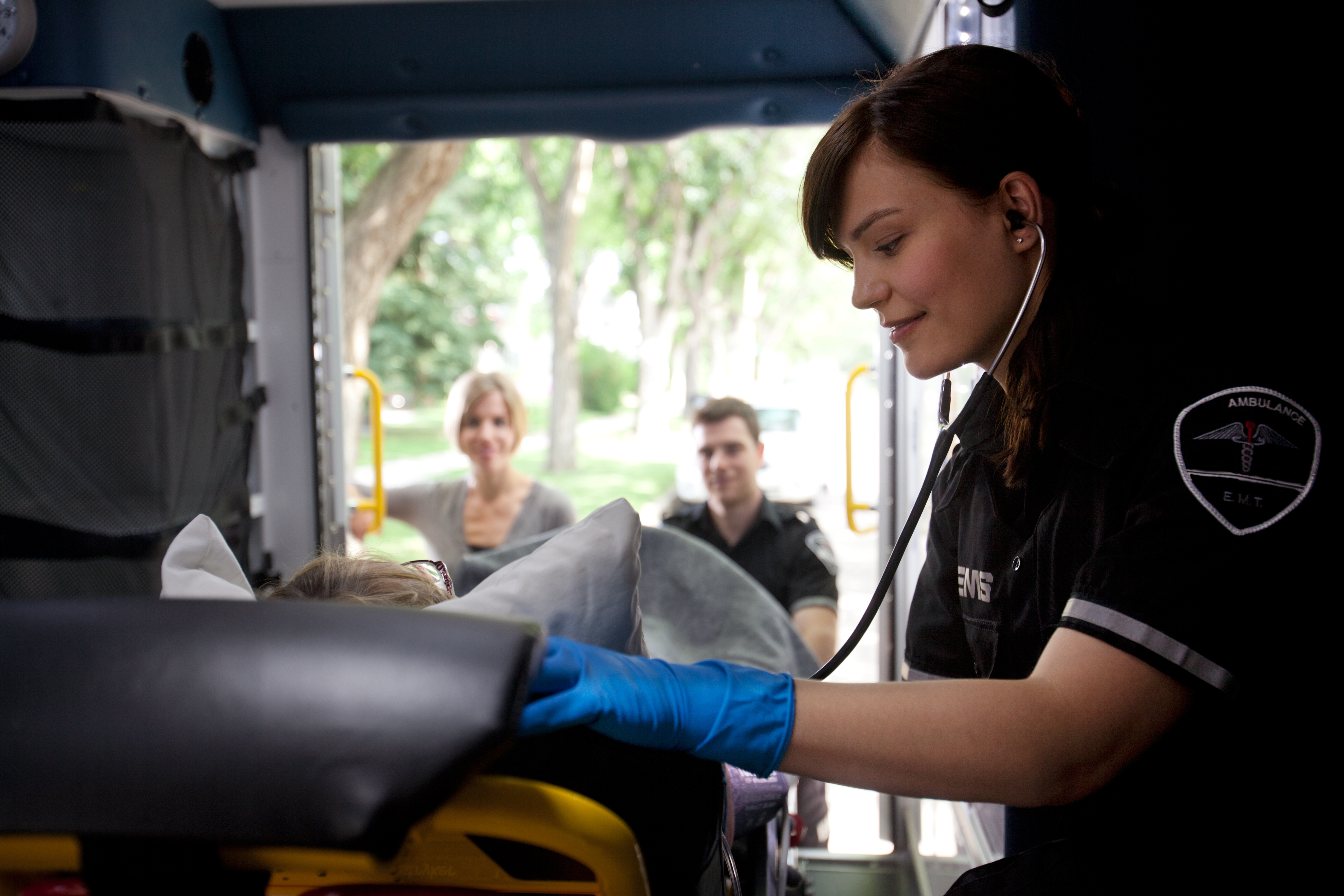 Paramedics helping a patient on stretcher inside ambulance