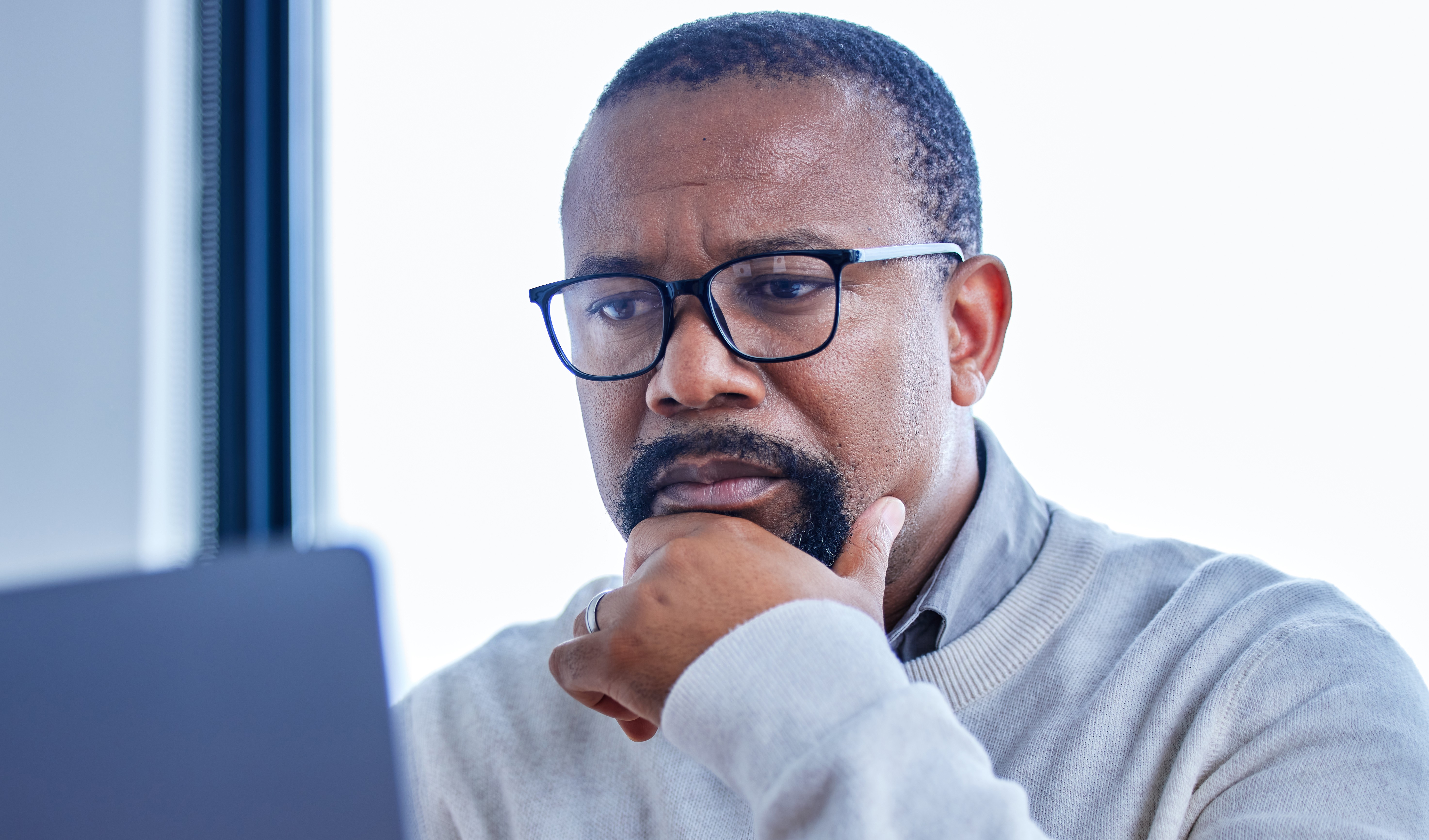 Man with a concerned facial expressions sitting at laptop