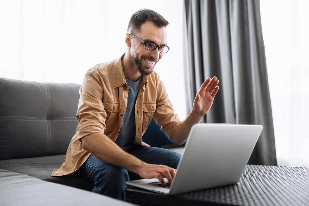 Man waving to a laptop online