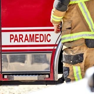 Firefighter EMS beside paramedic truck