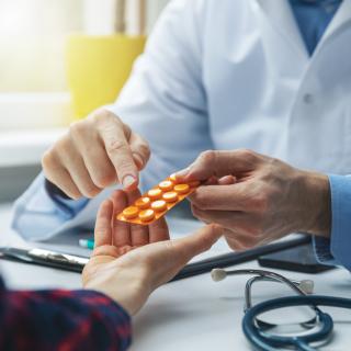 Pharmacist showing pill pack to patient