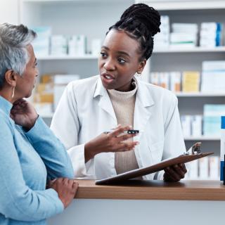 Pharmacy, medical or insurance with a customer and black woman pharmacist in a dispensary. Healthcare, clipboard and trust with a female medicine professional helping a patient in a drugstore